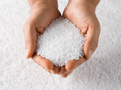 Hands holding recycled plastic pellets, representing the recycled process solutions provided by CTE.