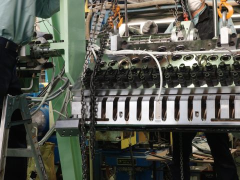 Production process at CTE, showing workers assembling a large extrusion machine with precision components.