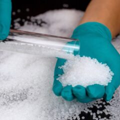 PVC resin pellets being handled during material evaluation, illustrating the raw materials used in PVC compounding and extrusion processes.