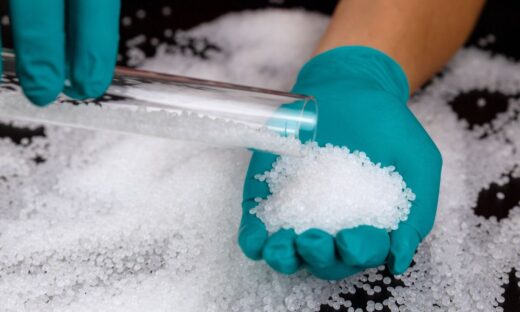 PVC resin pellets being handled during material evaluation, illustrating the raw materials used in PVC compounding and extrusion processes.