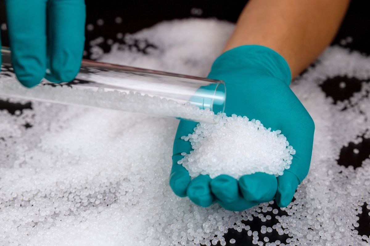 PVC resin pellets being handled during material evaluation, illustrating the raw materials used in PVC compounding and extrusion processes.