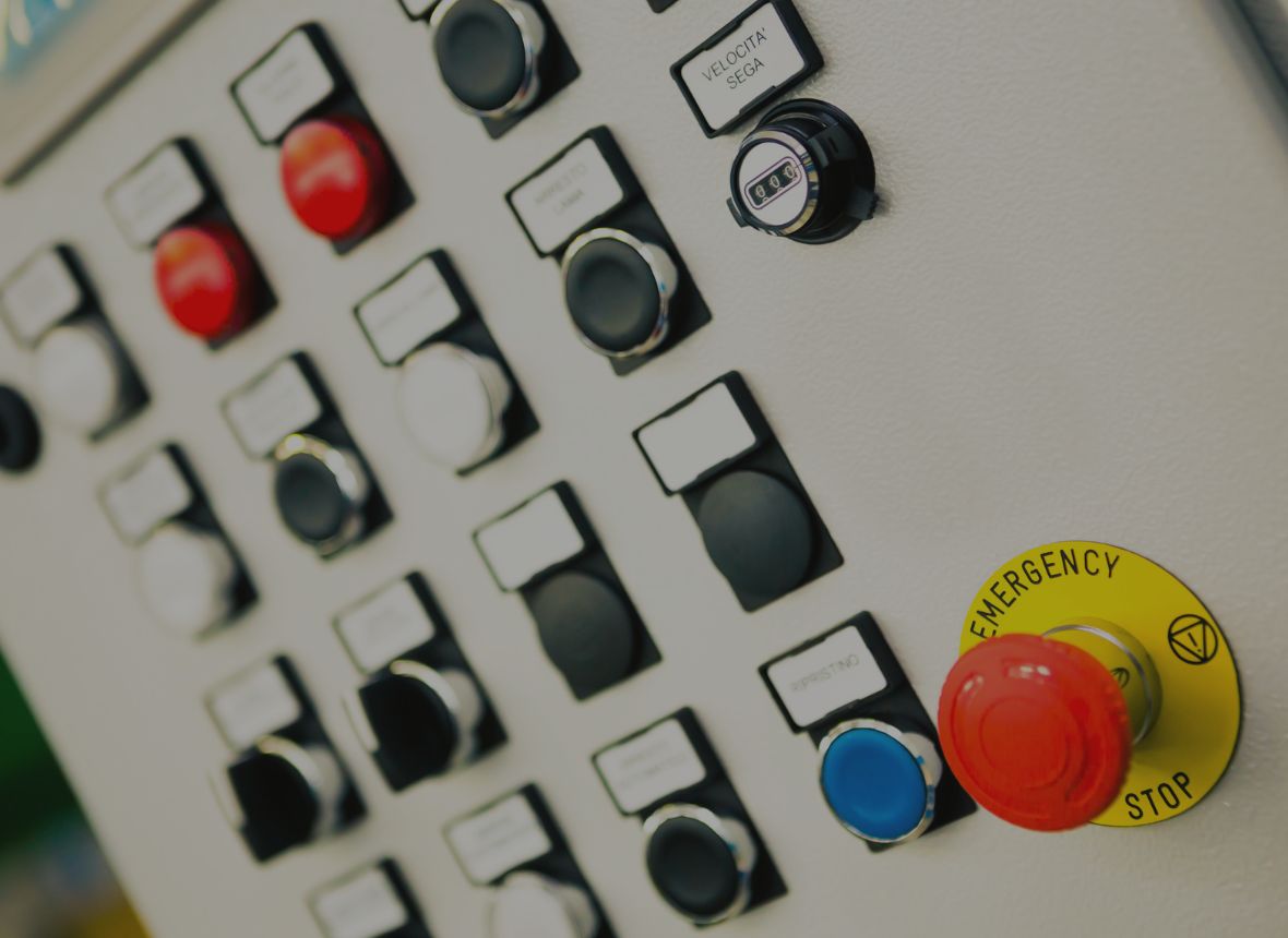 A control panel with multiple buttons and an emergency stop button, representing control systems for peripheral equipment in extrusion lines.