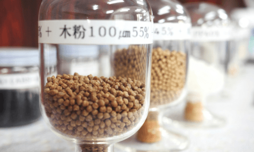 Jars containing plastic and wood powder pellets, representing CTE’s sustainable material compounding expertise, labeled with particle sizes and concentrations.