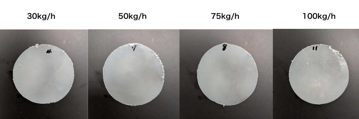 異なる吐出量（30kg/h、50kg/h、75kg/h、100kg/h）で処理されたテストサンプルの比較画像。吐出量が増加するにつれて、材料の品質や分散の均一性に変化が見られる様子を示しており、押出機の性能を様々な条件下で評価しています。